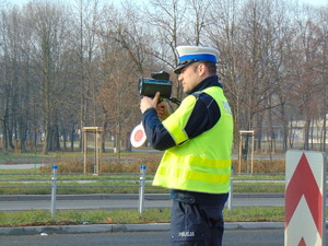 policjant ruchu drogowego z miernikiem prędkości w ręce
