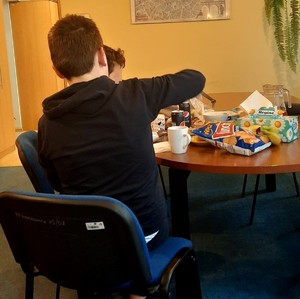 dwóch ukraińskich chłopców siedzących przy stole w komisariacie spożywają posiłek