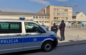 dworzec autobusowy w Nowym Sączu - policjantka i strażnik miejski przy oznakowanym radiowozie Policji