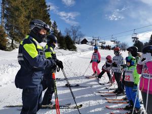 patrol narciarski z narciarzami na stoku