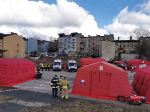 Policjanci, strażacy oraz rozłożone namioty i karetki pogotowia, w których moga schronic się uchodźcy