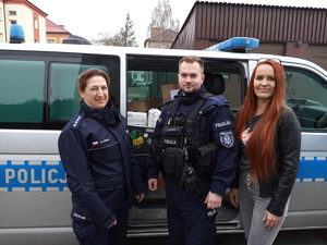KPP Oświęcim. Policjant policjantka oraz pracowniczka cywilna przy radiowozie