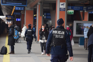 policjanci patrolujący peron dworca kolejowego