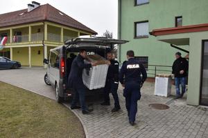 policjant wspólnie z prezesem Ł. Sadkiewicz wynoszą pralkę z samochodu