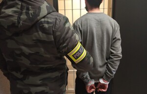 policjant pionu kryminalnego z zatrzymanym
