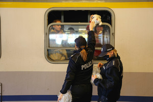 policjanci dają misie rodzicom dzieci w pociągu