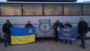 policjanci przy autobusie z flagami