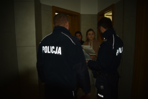 Policjanci przekazujący dwóm kobietom ulotki informacyjne