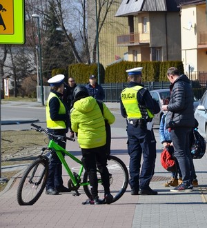 policjanci przekazują ulotki i odblaski pieszym i rowerzyście