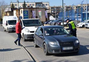 policjant i przedstawiciel MORD wręczają kierowcom ulotki