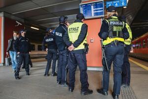 Policjanci stoją na peronie w oczekiwaniu na pociąg ze wschodu