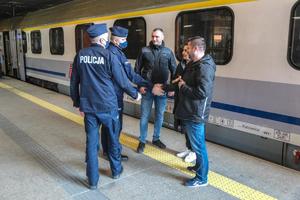 Komendant komendy miejskiej z Krakowa i jego zastępca witają się z uchodźcami