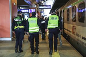 policjantka i strażnicy ochrony kolei na peronie