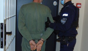 zatrzymany prowadzony przez umundurowanego policjanta