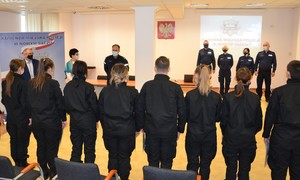 zdjęcie wykonane podczas spotkania w sali konferencyjnej - uczniowie, dyrektor i naczyciel oraz komendant, naczelnik i troje innych policjantów