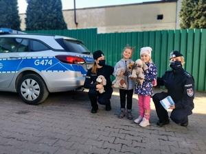 Policjantki z Ukraińskimi dziewczynkami przy policyjnym radiowozie.