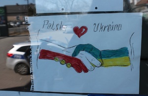 uścisk dłoni pomalowanych w barwach Polski i Ukrainy