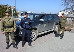 strażnicy Państwowej Straży  Rybackiej oraz policjant przy samochodzie PSR