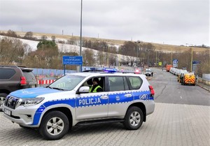 policyjny radiowóz, w oddali konwój na granicy Polski ze Słowacją
