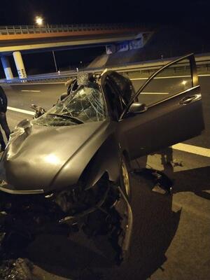 uszkodzony samochód osobowy, widok z przodu, z tyłu widoczny wiadukt, pora nocna