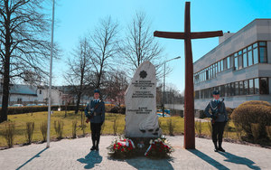 Pomnik z dwoma wieńcami. Dwóch policjantów asysty honorowej