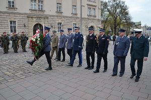 komendant wojewódzki Policji wraz z przedstawicielami innych służb składa wieniec pod krzyżem Katyńskim