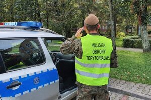 Żołnierz WOT stojący przy radiowozie