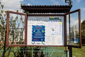 Gablota informacyjna na terenie ogrodu działkowego z umieszczonym plakatem akcji