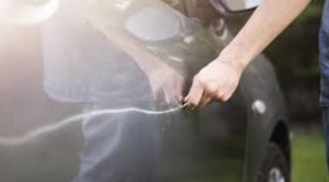 osoba zarysowująca karoserię samochodu