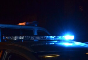 zdjęcie radiowozu w nocy z zaświeconymi sygnałami świetlnymi