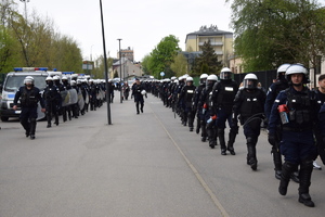 Policjanci Oddziału Prewencji Policji w Krakowie w dwóch rzędach idą w kierunku stadionu