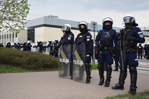 Policjanci z tarczami stoją przed stadionem