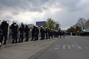 Umundurowani policjanci stoją wzdłuż bramy stadionu