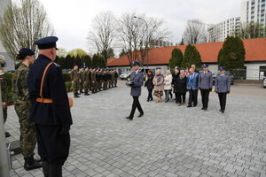 policjant niesie znicz, w tle zaproszeni goącie, funkcjonariusze i uczniowie klas munudrowych