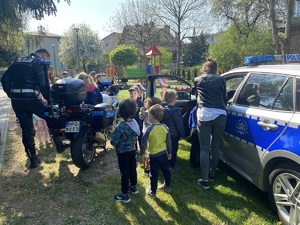 policjant prezentuje dzieciom policyjny motocykl