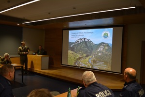 przedstawiciele Policji oraz parków narodowych oglądają prezentację  wyświetlaną na ekranie