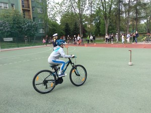 uczeń na rowerze pokonuje tor przeszkód podczas egzaminu na kartę rowerową