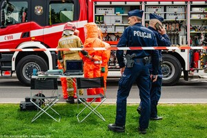 policjanci zabezpieczają teren, w tle karetka pogotowia oraz inne słuzby ratownicze