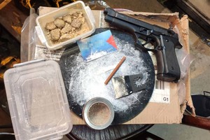 pistolet, biała substancja i bryłki białej substancji w plastykowym pudełku