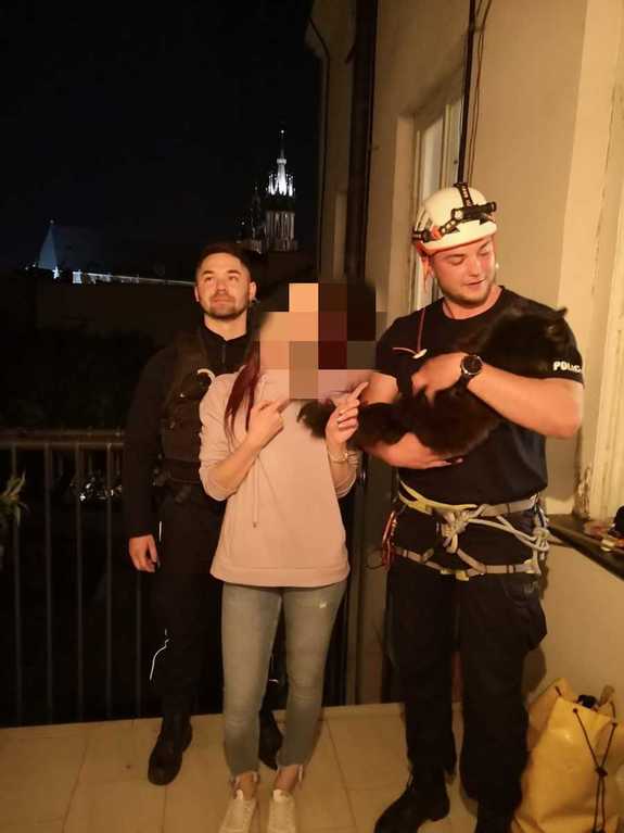 Policjant z uratowanym kotem, policjant z patrolu a pomiędzy nimi właścicielka czwronoga