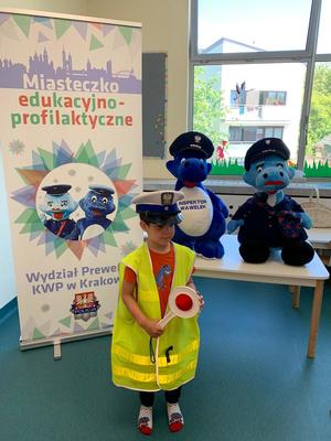 przedszkolak w stroju policjanta z maskotkami małopolskiej policji