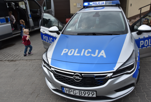 Dwa policyjne radiowozy oraz dzieci