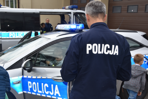 Dwa policyjne radiowozy, dwóch policjantów oraz dzieci