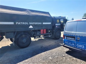pojazd patrolu saperskiego i fragment policyjnego radiowozu