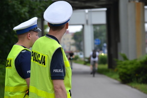 Policjanci ruchu drogowego nadzorują ruch na drodze dla rowerów.