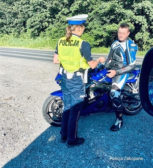 policjant z drogówki kontroluje motocyklistę