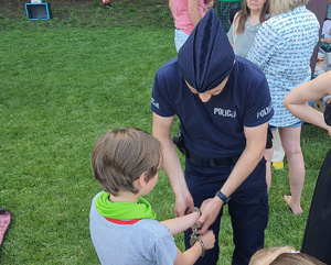 policjant prezentuje dziecku kajdanki
