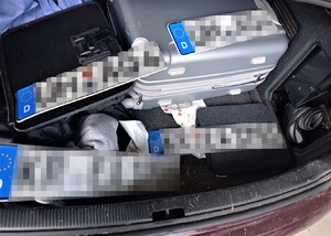 wnętrze bagażnika audi - cztery tablice rejestracyjne walizki odzież