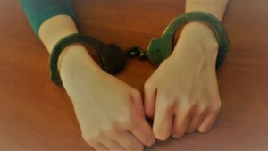 zdjęcie poglądowe, kobiece dłonie z założonymi kajdankami