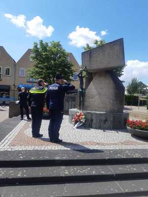 Policjant Polski i Holenderski składają kwiaty przed pomnikiem